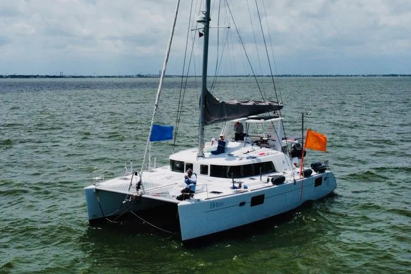 Slide: The Image of 2006 Lagoon 440 catamaran sailing on open water with colorful flags. - 7