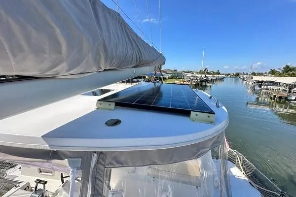 Slide: The Image of Lagoon 440 catamaran (2006) with solar panels, docked in a sunny marina. - 9