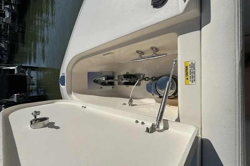 Slide: The Image of 2016 Grady-White Freedom 307 boat anchor compartment with caution label and hydraulic support. - 15