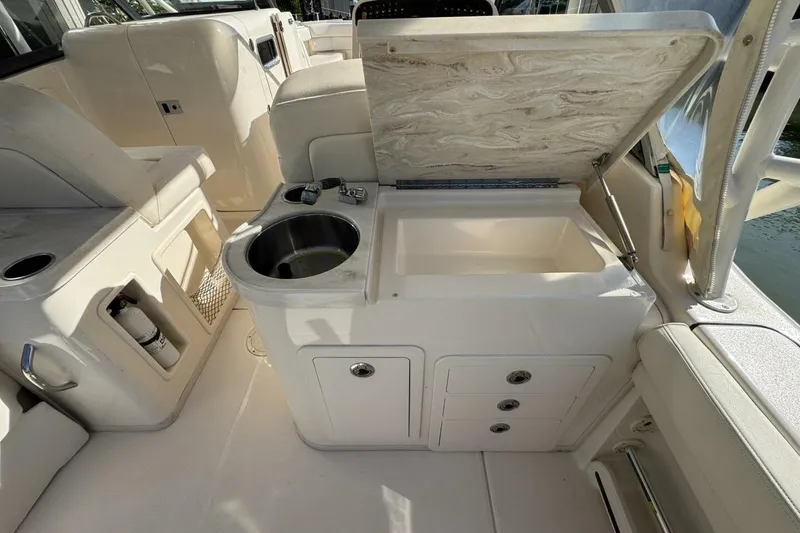 Slide: The Image of 2016 Grady-White Freedom 307 boat interior with sink and storage compartments. - 18