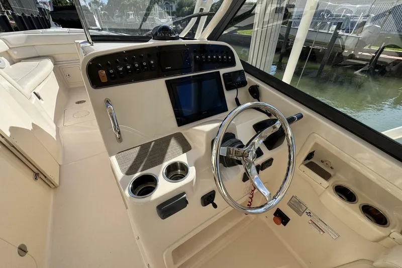 Slide: The Image of 2016 Grady-White Freedom 307 boat cockpit with steering wheel and control panel. - 2