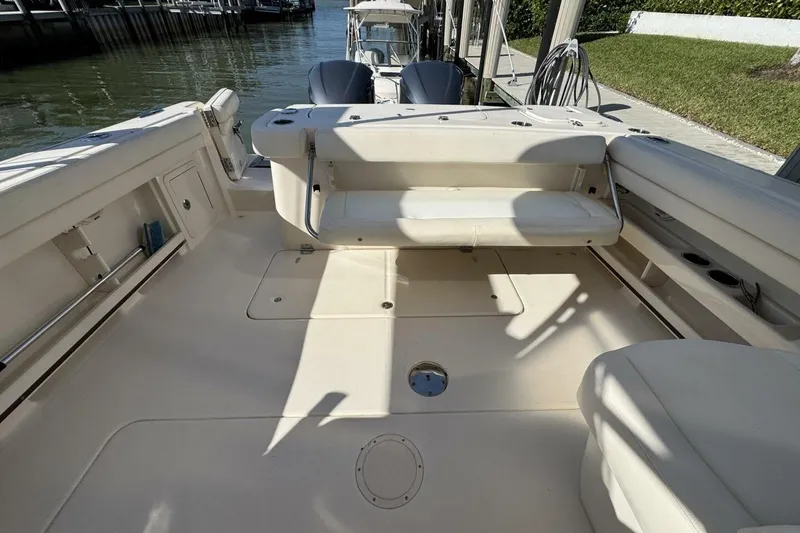 Slide: The Image of 2016 Grady-White Freedom 307 boat interior with seating and storage, docked by the water. - 20