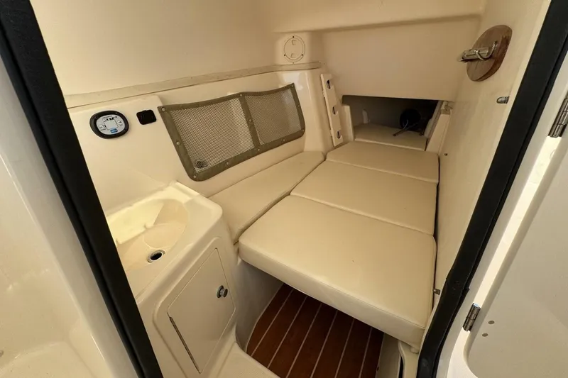 Slide: The Image of 2016 Grady-White Freedom 307 cabin interior with cushioned seating and storage. - 23