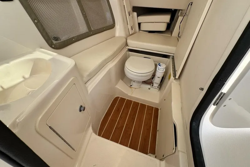 Slide: The Image of 2016 Grady-White Freedom 307 boat interior with toilet and seating area. - 24
