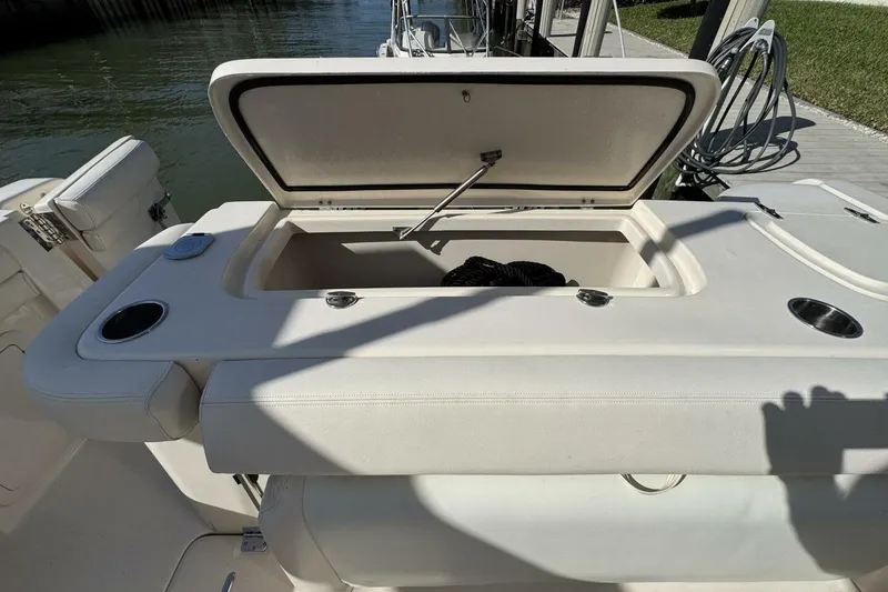 Slide: The Image of 2016 Grady-White Freedom 307 boat with open storage compartment, dockside view. - 25