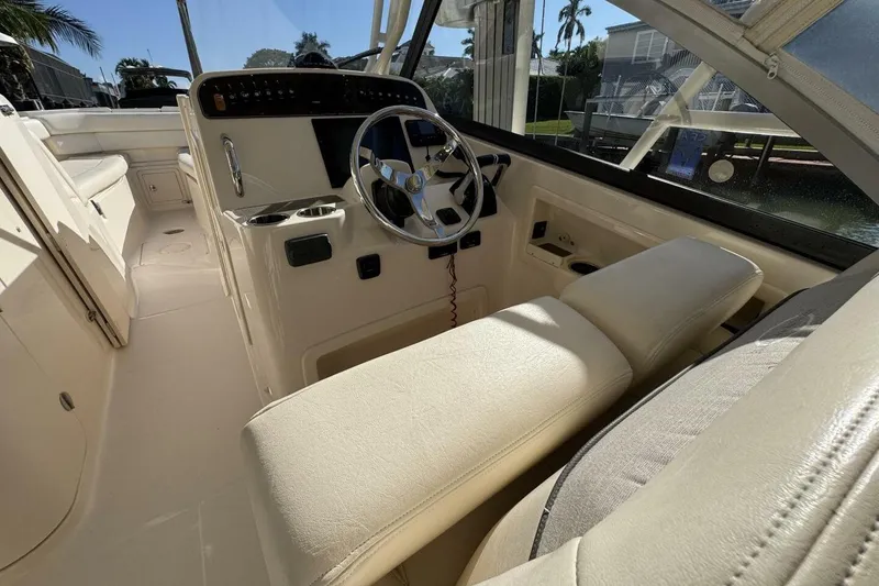 Slide: The Image of 2016 Grady-White Freedom 307 boat interior with steering wheel and seating. - 6