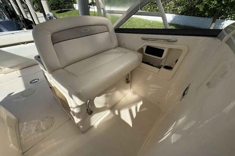 Slide: The Image of 2016 Grady-White Freedom 307 boat interior with cushioned seating and storage compartment. - 9