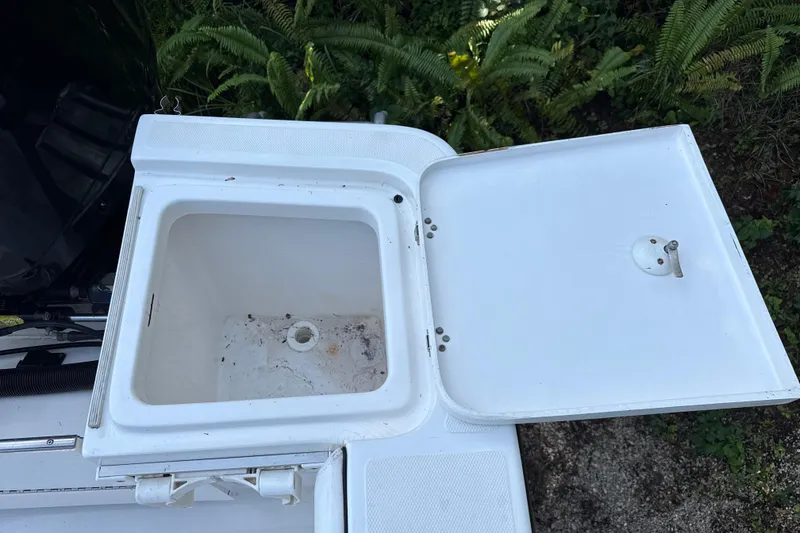 Slide: The Image of Open storage compartment on 2002 SeaCraft SC32 Master Angler boat, surrounded by greenery. - 13