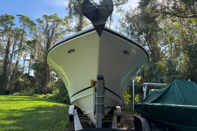 Slide: The Image of 2002 SeaCraft SC32 Master Angler boat on trailer, surrounded by lush greenery. - 2
