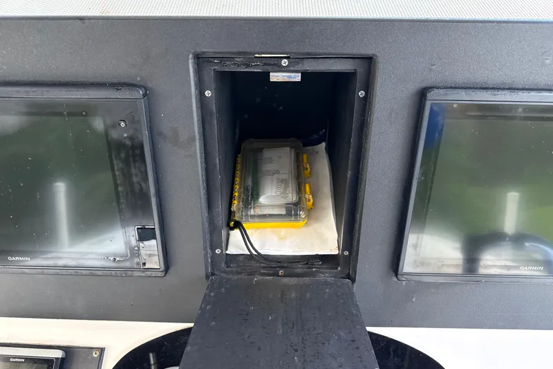 Slide: The Image of 2002 SeaCraft SC32 Master Angler dashboard with Garmin screens and storage compartment. - 26