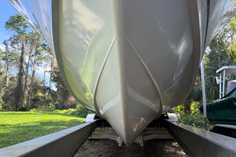 Slide: The Image of 2002 SeaCraft SC32 Master Angler boat hull on trailer, surrounded by lush greenery. - 3