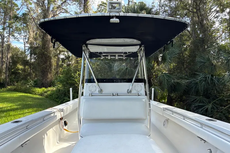 Slide: The Image of 2002 SeaCraft SC32 Master Angler boat with canopy, surrounded by lush greenery. - 31