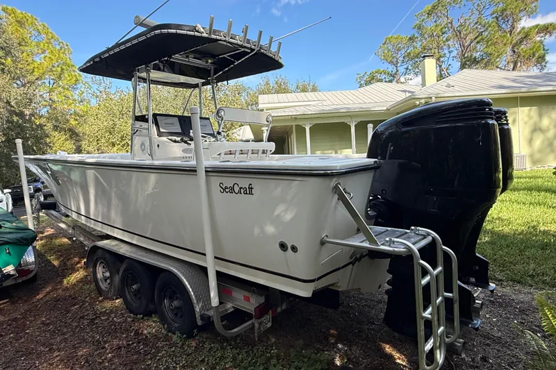 Slide: The Image of 2002 SeaCraft SC32 Master Angler boat on trailer, parked outdoors near a house. - 4