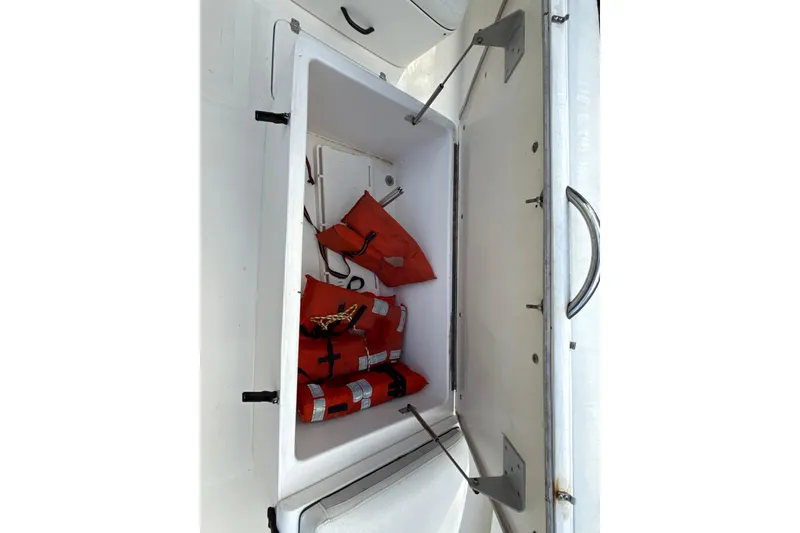 Slide: The Image of Open storage compartment on 2002 SeaCraft SC32 Master Angler with life jackets inside. - 48