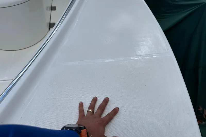 Slide: The Image of Hand touching deck of 2002 SeaCraft SC32 Master Angler boat. - 51