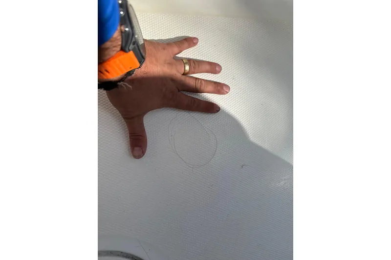 Slide: The Image of Hand inspecting SeaCraft SC32 Master Angler 2002 boat surface for damage. - 52