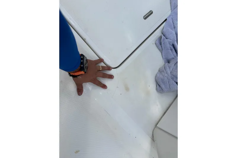 Slide: The Image of Hand on SeaCraft SC32 Master Angler 2002 deck, with towel nearby. - 54