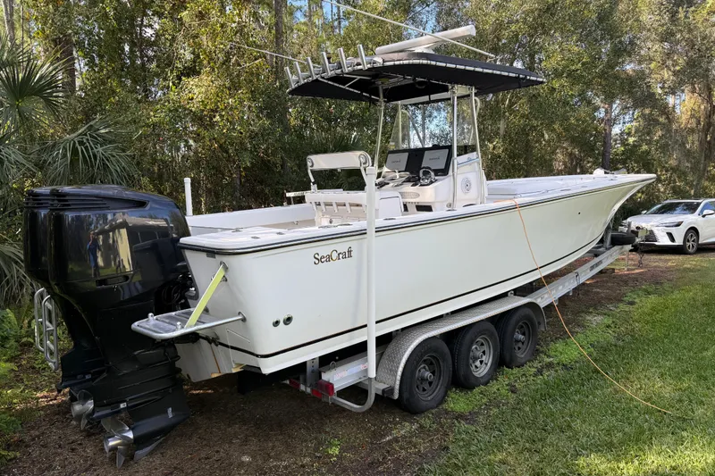 Slide: The Image of 2002 SeaCraft SC32 Master Angler boat on trailer, parked in a wooded area. - 6