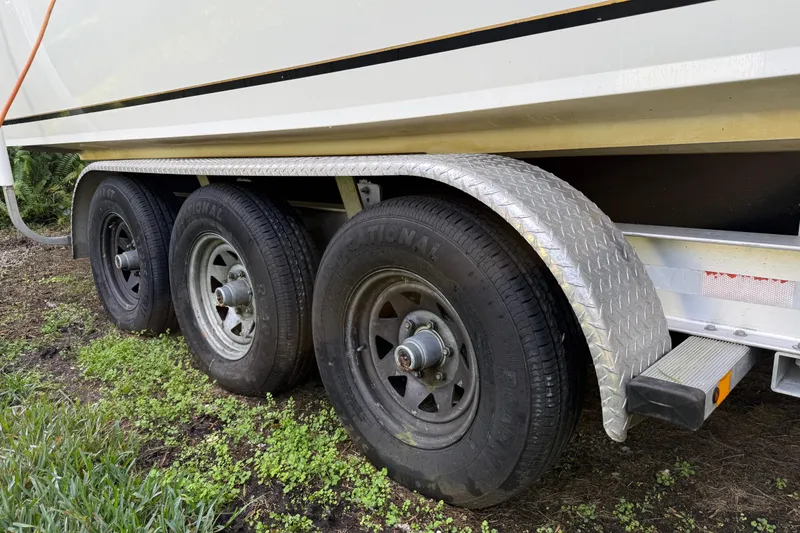 Slide: The Image of Trailer wheels of a 2002 SeaCraft SC32 Master Angler boat on grass. - 8