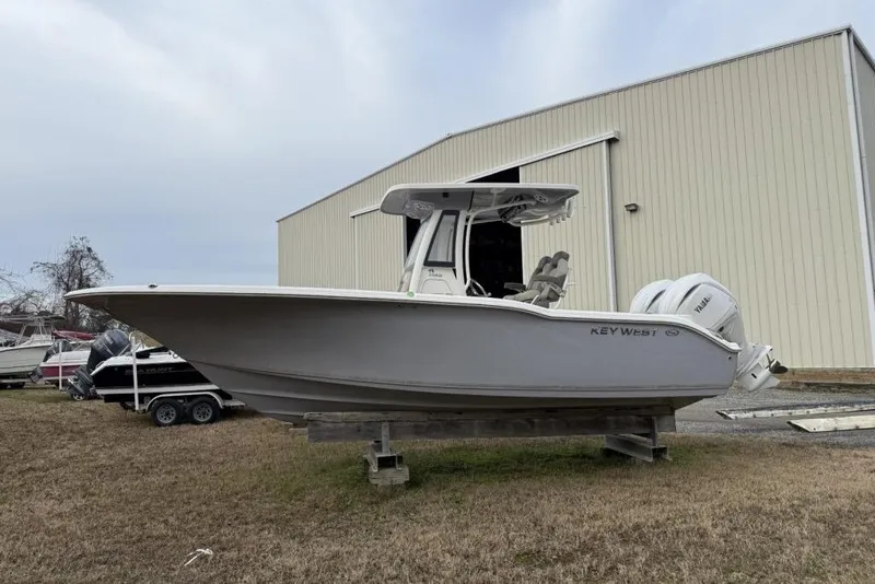 The Image of 2026 Key West 244 Center Console boat on trailer, parked outdoors under clear sky. - 0