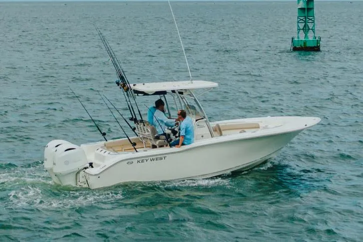 Slide: The Image of 2026 Key West 244 Center Console boat, white deck, parked near storage buildings. - 16