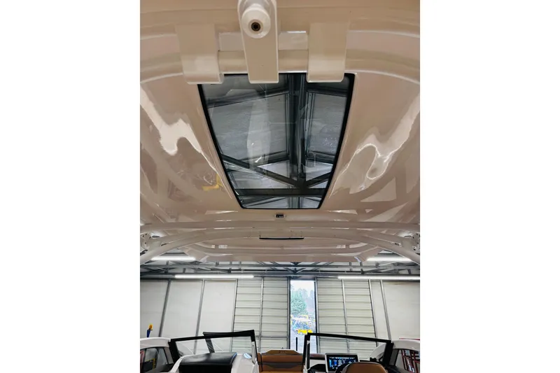 Slide: The Image of 2024 Yamaha Boats 275SD interior roof with sunroof in a garage setting. - 23