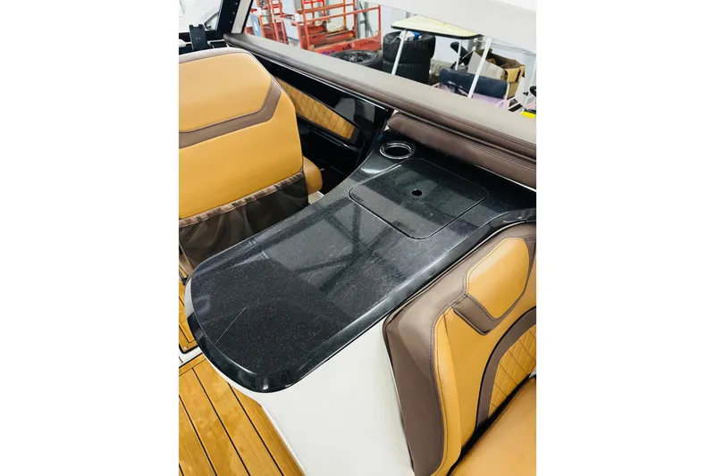 Slide: The Image of 2024 Yamaha Boats 275SD interior with sleek black countertop and tan seating. - 25