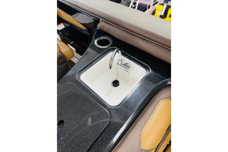 Slide: The Image of 2024 Yamaha Boats 275SD interior sink with sleek black countertop and modern faucet. - 26