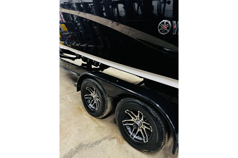Slide: The Image of 2024 Yamaha Boats 275SD trailer with sleek black design and stylish wheels. - 30