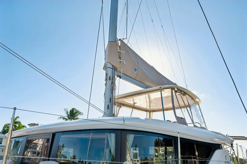 Slide: The Image of 2022 Lagoon 46 catamaran with sails, docked under clear blue sky. - 12