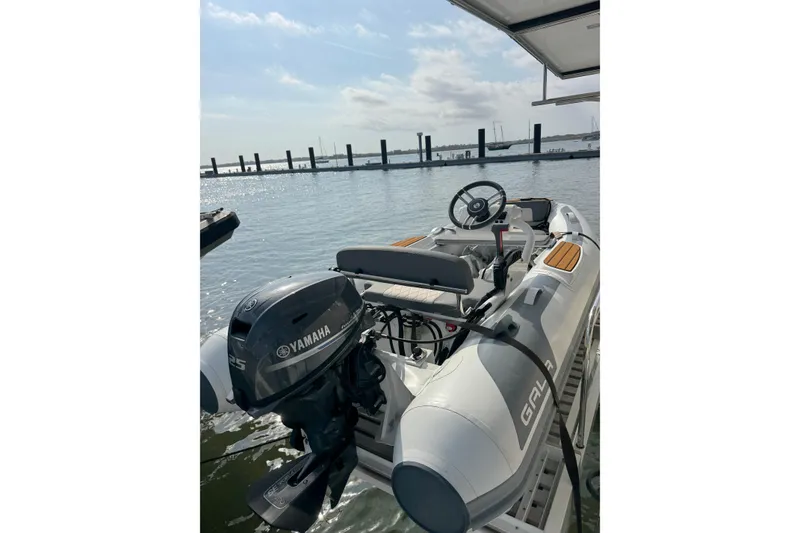 Slide: The Image of Inflatable boat with Yamaha motor on Lagoon 46, 2022 model, docked by the water. - 120