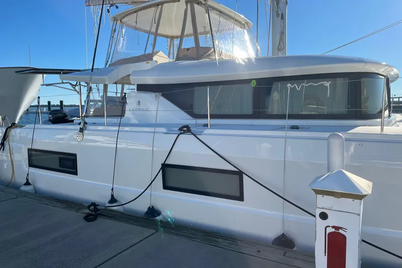Slide: The Image of 2022 Lagoon 46 catamaran docked at marina under clear blue sky. - 121