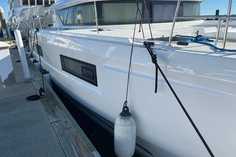 Slide: The Image of 2022 Lagoon 46 catamaran docked at marina, showcasing sleek design and modern features. - 122