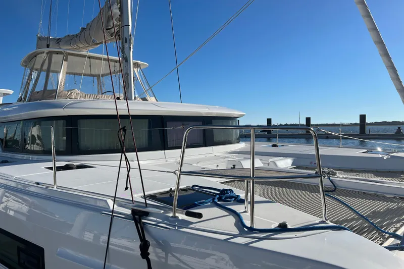 Slide: The Image of 2022 Lagoon 46 catamaran docked, featuring sleek design and spacious deck. - 123