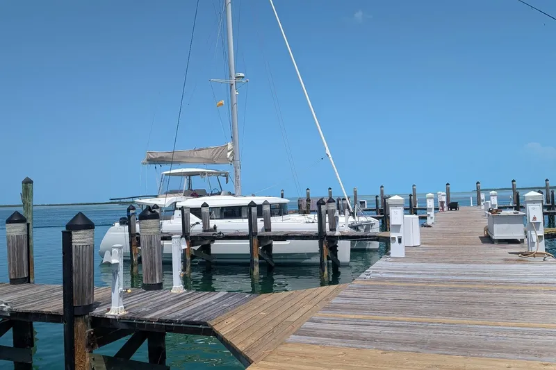 Slide: The Image of 2022 Lagoon 46 catamaran docked at a sunny marina. - 126