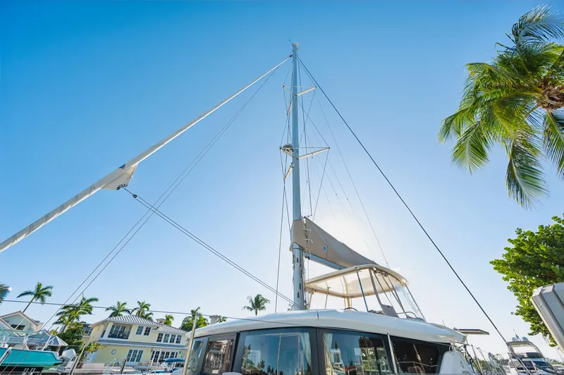 Slide: The Image of 2022 Lagoon 46 catamaran docked under clear blue sky with palm trees. - 13