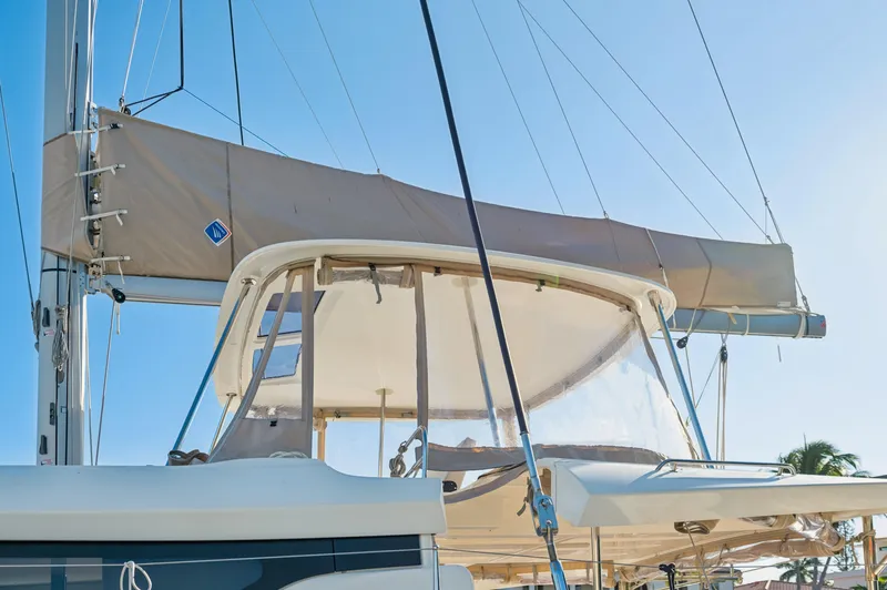 Slide: The Image of 2022 Lagoon 46 catamaran with sails, viewed from the deck under clear blue sky. - 14