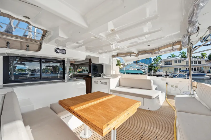 Slide: The Image of Spacious interior of 2022 Lagoon 46 catamaran with wooden table and comfortable seating. - 16