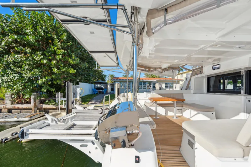 Slide: The Image of 2022 Lagoon 46 catamaran docked, featuring spacious deck and seating area under clear blue sky. - 26