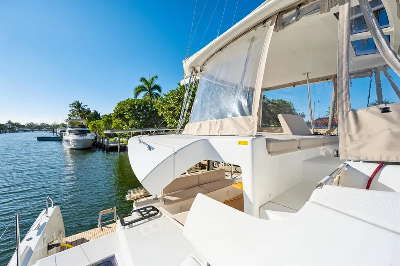 Slide: The Image of 2022 Lagoon 46 catamaran docked by a scenic waterfront with palm trees. - 31