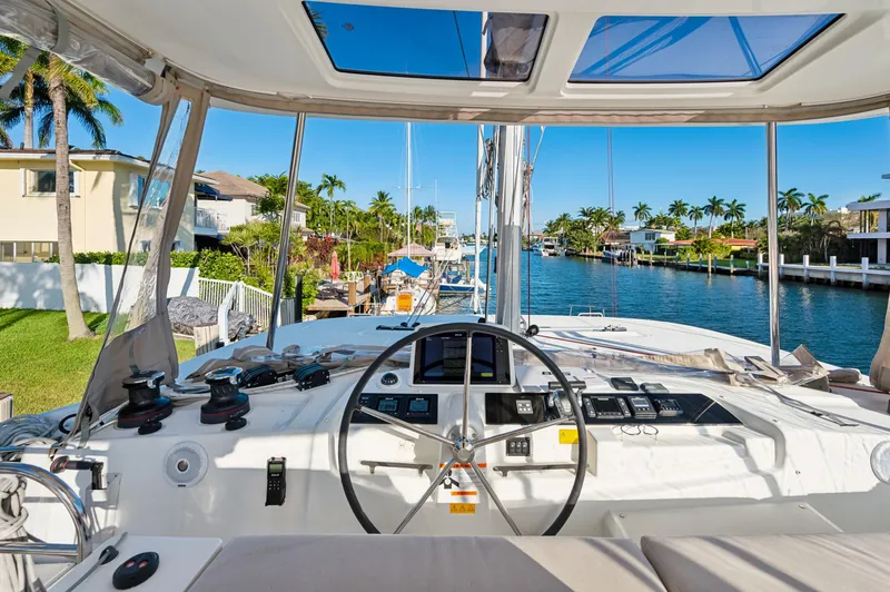 Slide: The Image of Cockpit view of 2022 Lagoon 46 catamaran docked in a sunny marina. - 34