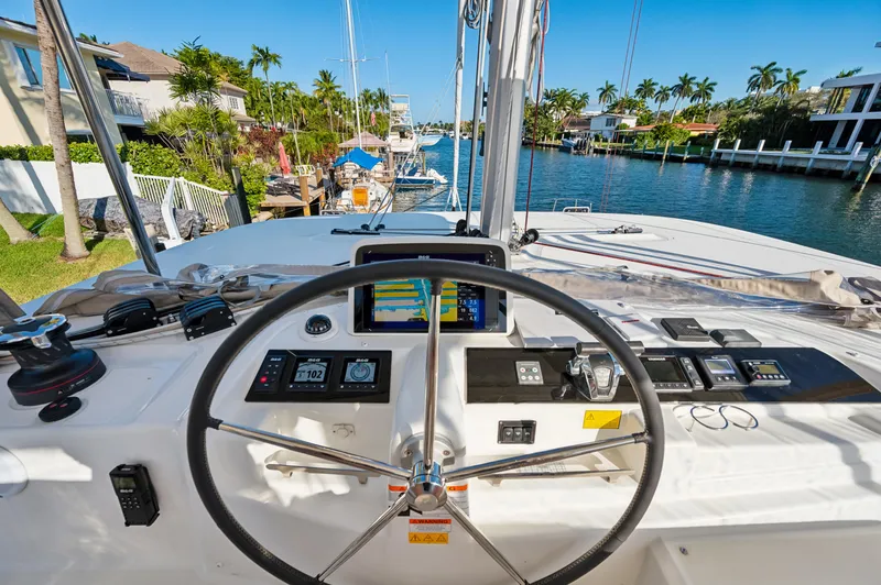 Slide: The Image of 2022 Lagoon 46 yacht helm with navigation instruments, overlooking a scenic waterfront. - 35