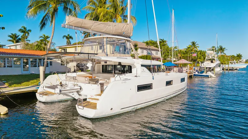 Slide: The Image of 2022 Lagoon 46 catamaran docked in a sunny marina with palm trees. - 4
