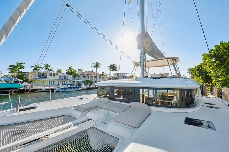 Slide: The Image of 2022 Lagoon 46 catamaran docked in sunny marina with palm trees. - 44