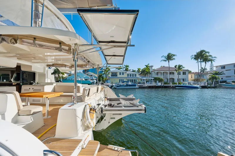 Slide: The Image of 2022 Lagoon 46 yacht docked in sunny waterfront setting with palm trees. - 6