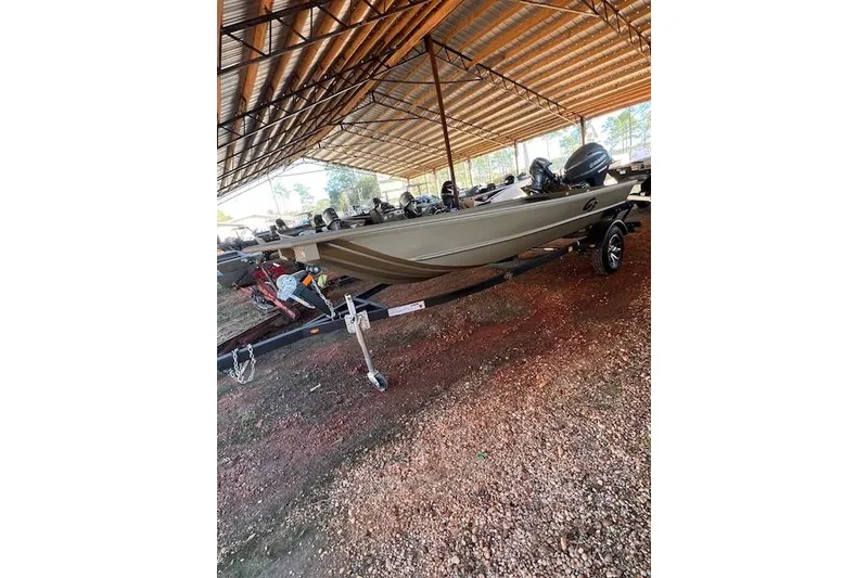 The Image of 2025 G3 Gator Tough 15 DK boat on trailer under a metal canopy. - 1
