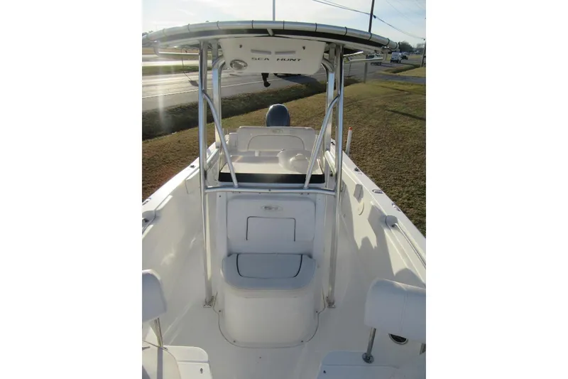 Slide: The Image of 2014 Sea Hunt Ultra 234 boat with T-top and seating, parked on grass. - 10