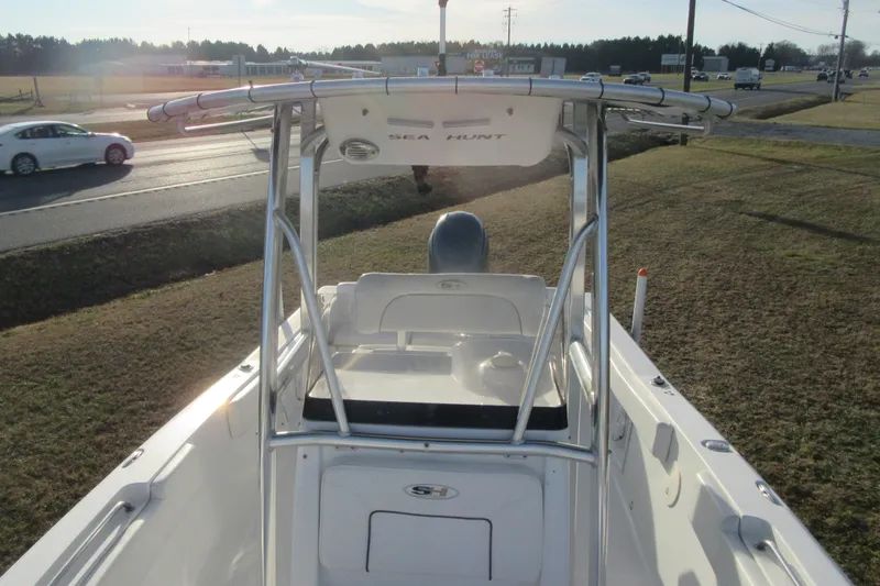 Slide: The Image of 2014 Sea Hunt Ultra 234 boat with T-top, parked near a road. - 12