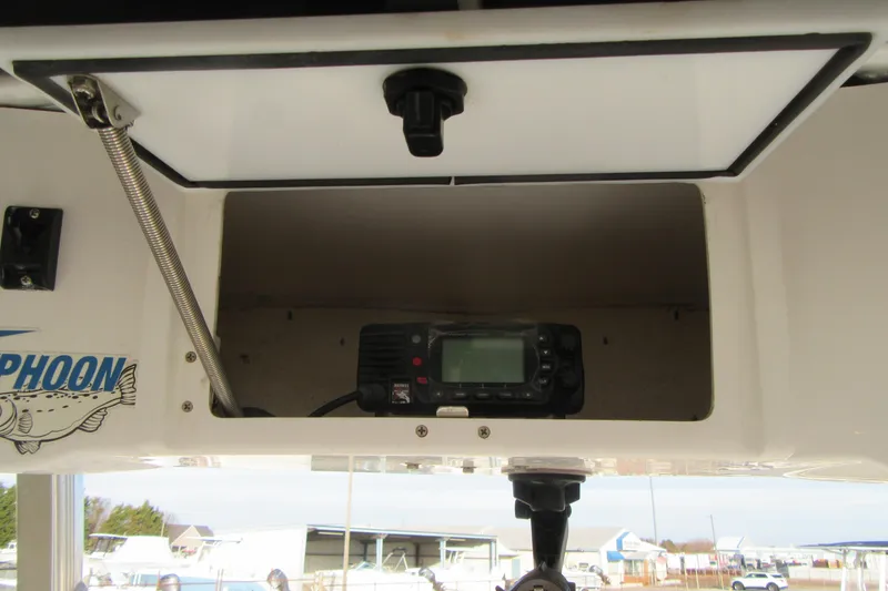 Slide: The Image of 2014 Sea Hunt Ultra 234 boat compartment with radio equipment. - 22