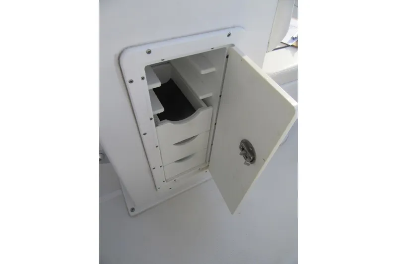 Slide: The Image of Open storage compartment on 2014 Sea Hunt Ultra 234 boat, featuring multiple drawers. - 26